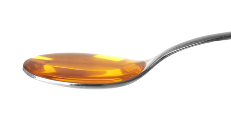 Yellow cough medicine syrup in silver spoon isolated on white