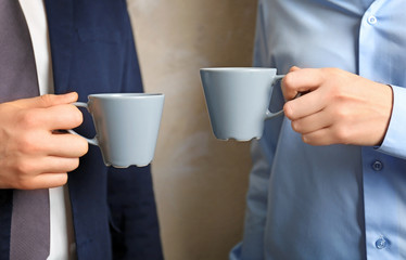 Blank color cups in hands, closeup