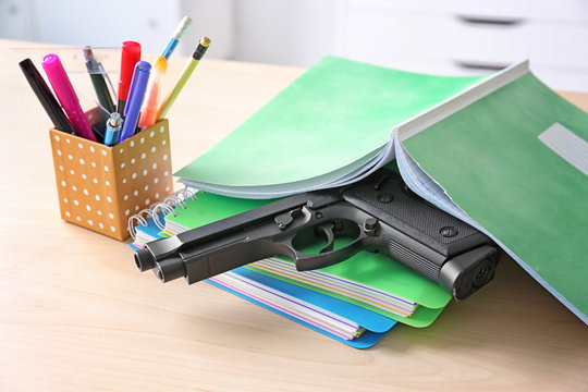 School Stationery And Gun On Table In Class