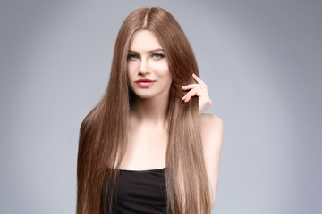 Attractive young woman with beautiful long hair on light background