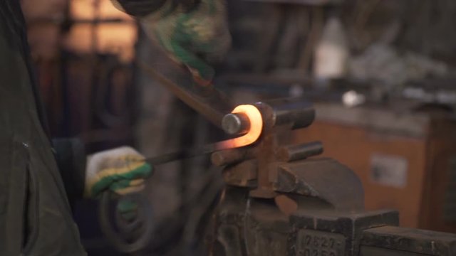 The blacksmith who shapes hot steal with a hammer