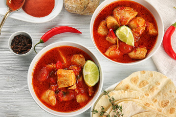 Portions of chicken tikka masala on white wooden table