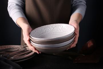 Female hands holding dishes, closeup