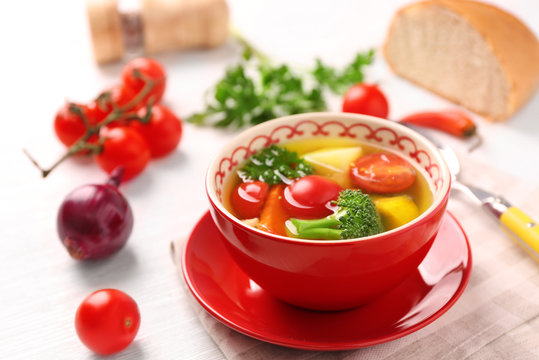 Bowl with vegetable soup on kitchen table