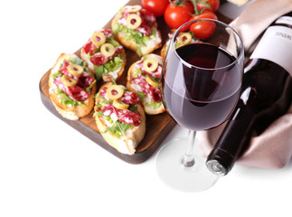 Tasty bruschetta served with wine on white background