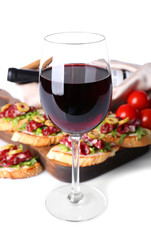 Glass of wine and tasty bruschettas on background