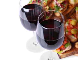 Glasses of wine and tasty bruschettas on background