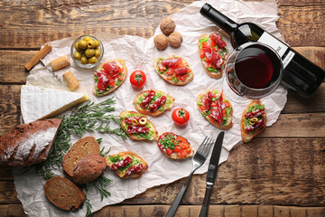 Tasty bruschetta served with wine on wooden background - obrazy, fototapety, plakaty
