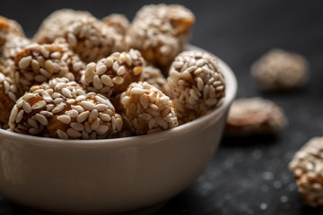 Nuts covered with sesame in white bowl, closeup shot