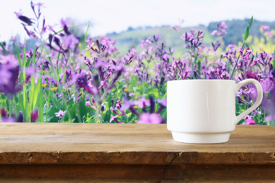 Cup of coffee a wooden table in front of spring landscape
