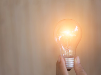 designer hand showing creative business strategy with light bulb as concept 