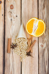 Cedar nuts, rolls of cinnamon and star anise on wooden table