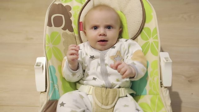 Baby shaking legs in the nursery rocking chair.
