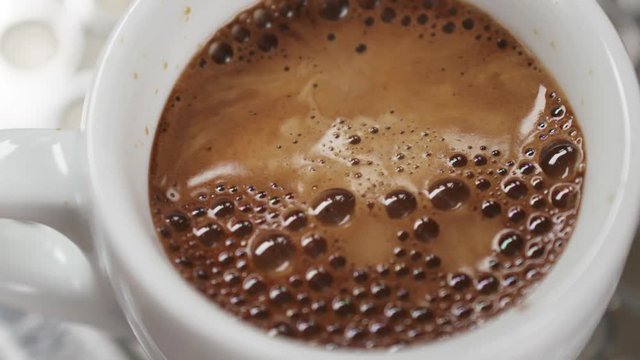 Slow motion of espresso brewing with professional coffee machine from above handheld, 180fps prores footage