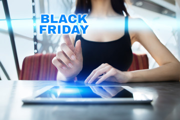 Woman is using tablet pc, pressing on virtual screen and selecting black friday.