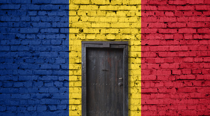 Romania flag on brick wall. Closed door in a wall