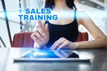 Woman is using tablet pc, pressing on virtual screen and selecting sales training.