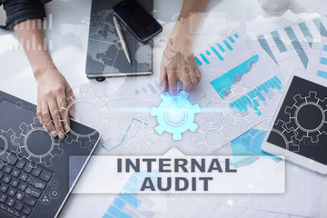 Woman is working with documents, tablet pc and notebook and selecting internal audit.