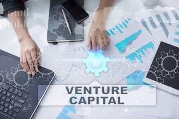 Woman is working with documents, tablet pc and notebook and selecting venture capital.