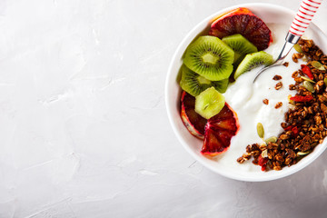 Granola,yogurt with kiwi and red oranges.Breakfast useful.Concept of Healthy Food.Copy space for Text. selective focus.