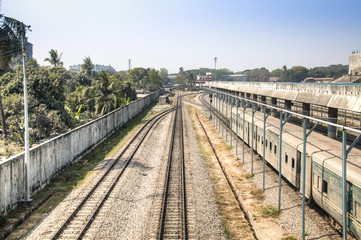 Fototapeta na wymiar Railroad tracks with a train in the station in Chittagong, the main port city of Bangladesh 