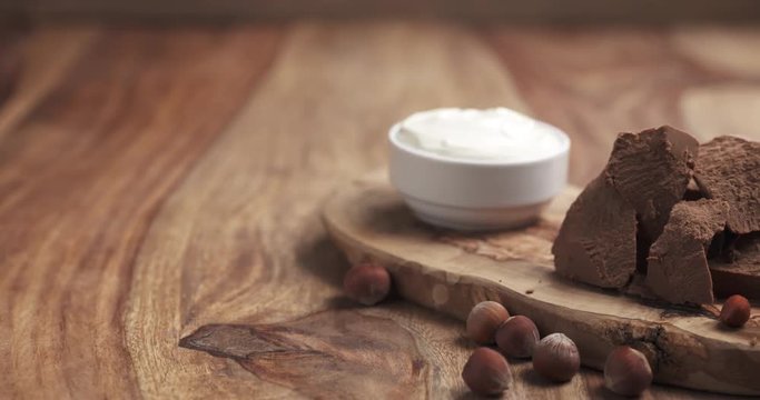 gianduja with hazelnuts and cream on wooden table slide movement 4k prores footage