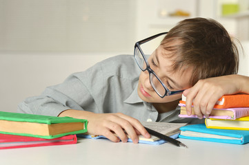 Boy in glasses sleeps on books