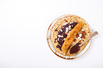 Thin Pancakes with Chocolate,Hazelnut on a White Background.Tradition,Holiday,Dessert,Breakfast.Copy space for Text. selective focus.