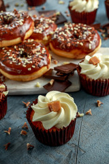 donut rings and vanilla caramel cupcakes with white and dark chocolate chippings and icing served on board
