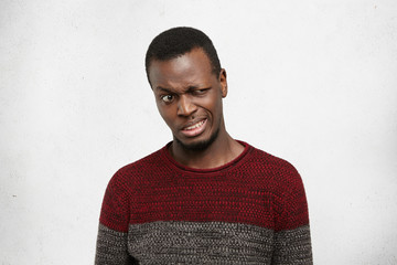 Human facial expressions, emotions and feelings. Studio shot of disgusted young African American...