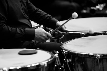 Fototapeta na wymiar Hands musician playing the timpani in the orchestra closeup in black and white
