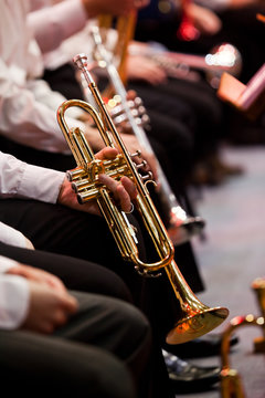 Hands of a musician holding a trumpet in an orchestra closeup