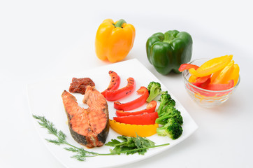 Grilled red fish with sauce, broccoli, parsley and dill  on a white plate