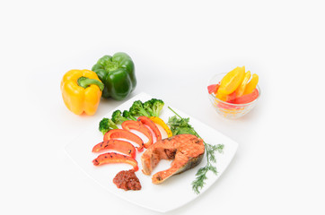 Grilled red fish with sauce, broccoli, parsley and dill  on a white plate