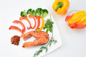 Grilled red fish with sauce, broccoli, parsley and dill  on a white plate