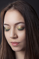 close-up portrait of girl with closed eyes and make-up cocktail on a black isolated background