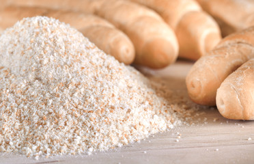 Pile of breadcrumbs and blurry bread rolls in the background