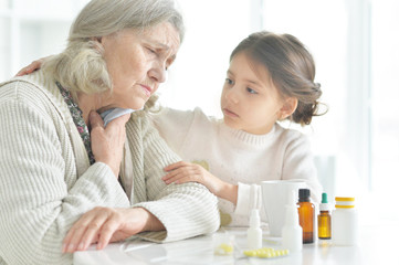 Obraz na płótnie Canvas Granddaughter takes care of a sick grandmother