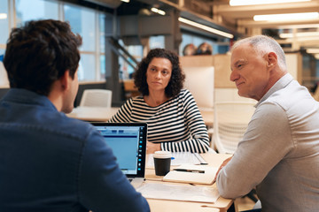 Work colleagues talking strategy together in an office
