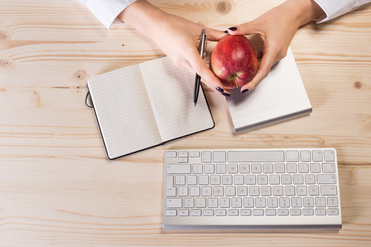 Business woman in an office holding red apple - Clipping Path