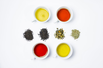 Collection of different teas in cups with tea leaves on a white background