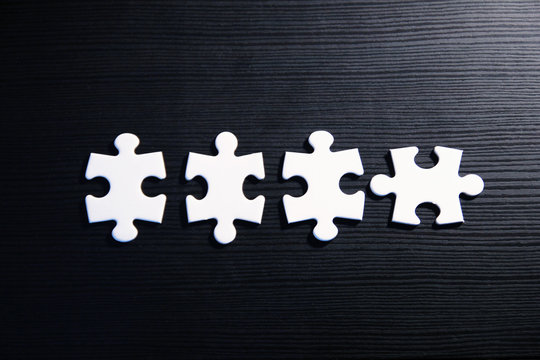 Vier Puzzleteile auf schwarzem Grund