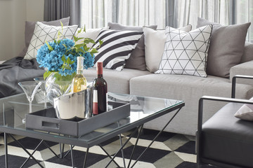 Bottles of wine and glasses on center table with mono tone setting living corner