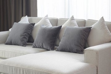 Two tone pillows lay on beige sofa in living room