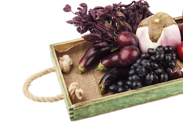 Set of different violet vegetables and fruits in the wooden tray