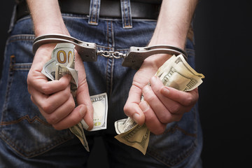 Man in handcuffs with money.