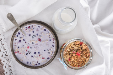 Milk cereal in brown bowl and bottle with milk and dry cereal, view from above. 