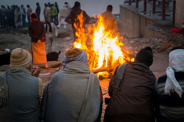 Cremation ceremony in Manikarnika Ghat on the Ganges River in Varanasi, People look at the funeral...