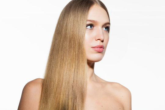 Beauty portrait of blonde model woman with long shiny hair and healthy skin looking at camera on white background