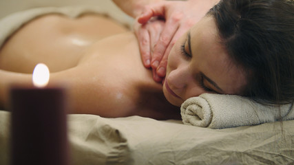 Obraz na płótnie Canvas Half nude young female in massage table at spa salon - oil relax massage, spa concept
